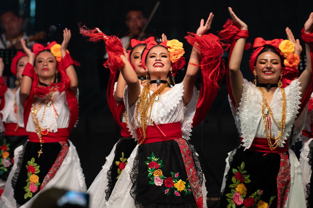 Plesačice iz gostujućeg ansambla u raskošnim vezenim nošnjama i sa crvenim maramama na festivalu